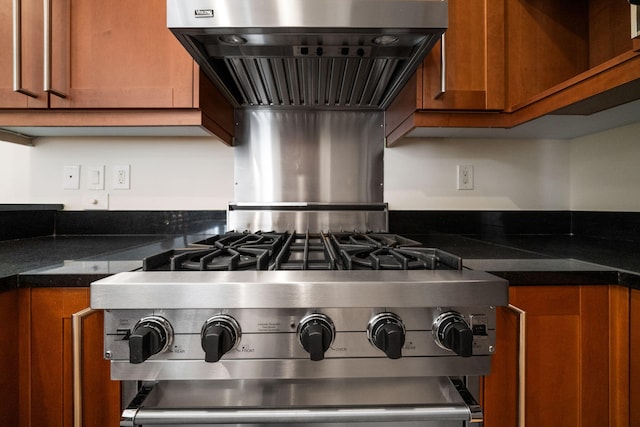 9201 Market St Inn Unit 159, Miramar Beach, FL 32550 - kitchen view of brown cabinets, ventilation hood, dark countertops, and stainless steel gas range