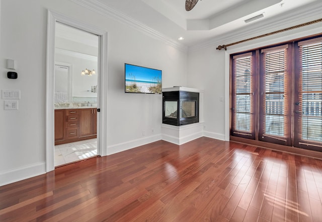 9201 Market St Inn Unit 159, Miramar Beach, FL 32550 - unfurnished living room featuring wood finished floors, french doors, baseboards, crown molding, and a multi sided fireplace