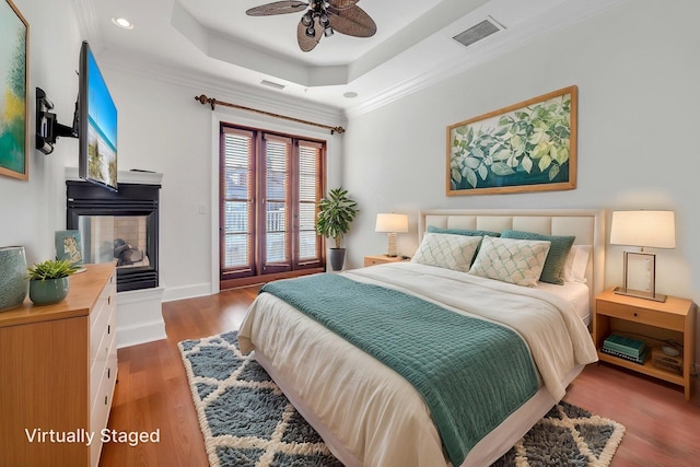 9201 Market St Inn Unit 159, Miramar Beach, FL 32550 - bedroom with multiple windows, a tray ceiling, access to outside, wood finished floors, and ornamental molding