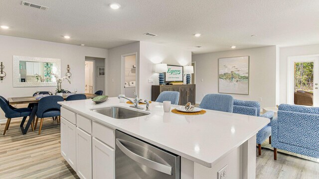3064 Heritage Plantation Blvd, Laurel Hill, FL 32567 - kitchen featuring stainless steel dishwasher, a sink, open floor plan, light wood finished floors, and a kitchen island with sink