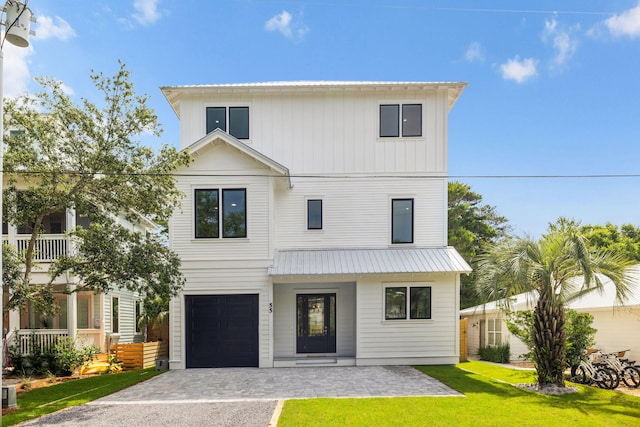 55 May Dr, Santa Rosa Beach, FL 32459 - view of front of home with decorative driveway, metal roof, a front yard, and an attached garage
