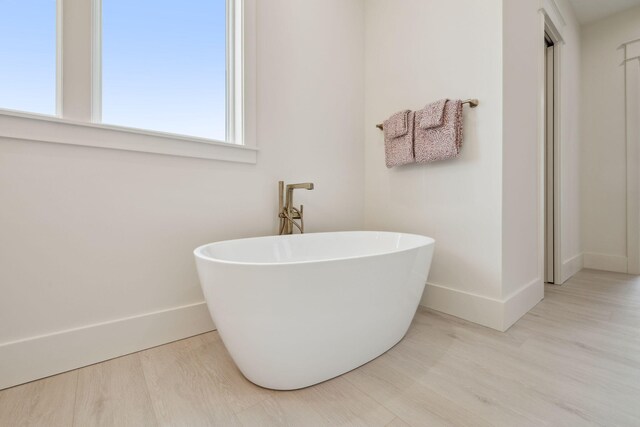 55 May Dr, Santa Rosa Beach, FL 32459 - full bath with baseboards, a freestanding tub, and wood finished floors