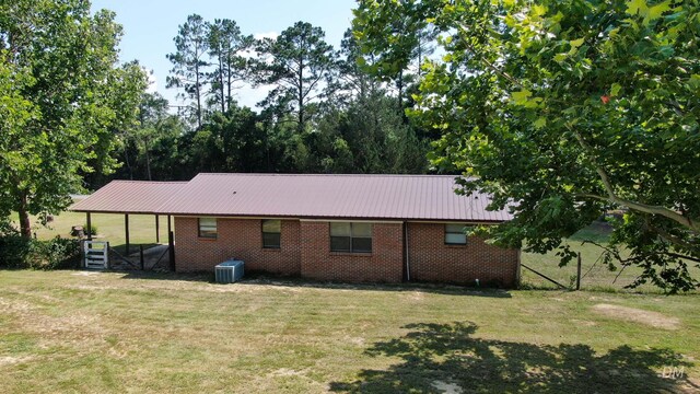 1737 S County Highway 183, Defuniak Springs, FL 32435 - rear view of house featuring a yard, brick siding, metal roof, and central air condition unit