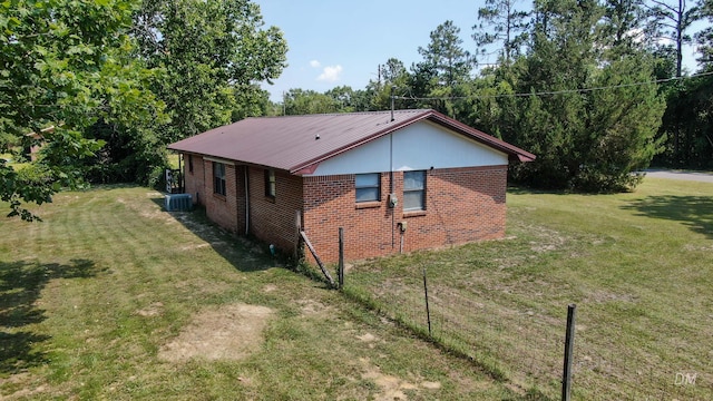 1737 S County Highway 183, Defuniak Springs, FL 32435 - view of side of home featuring brick siding, a lawn, central air condition unit, and metal roof