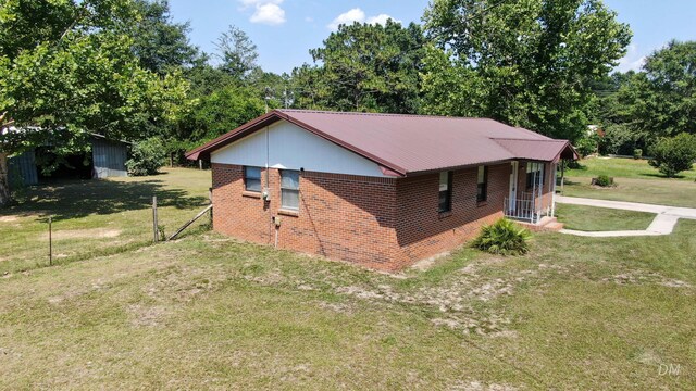 1737 S County Highway 183, Defuniak Springs, FL 32435 - view of property exterior featuring a yard, brick siding, and metal roof