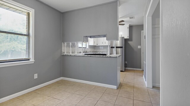1737 S County Highway 183, Defuniak Springs, FL 32435 - kitchen with freestanding refrigerator, white cabinetry, light tile patterned floors, a ceiling fan, and a peninsula