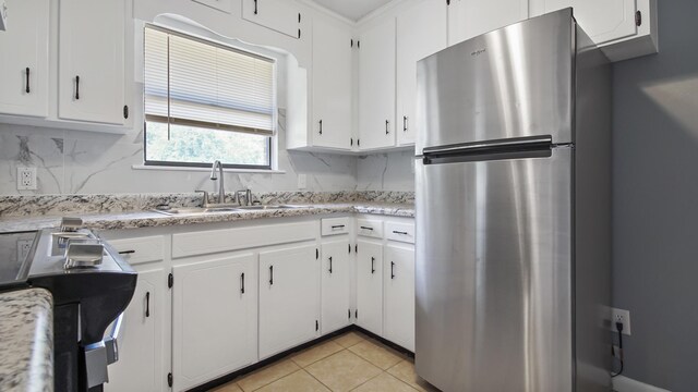 1737 S County Highway 183, Defuniak Springs, FL 32435 - kitchen featuring freestanding refrigerator, a sink, tasteful backsplash, and white cabinetry