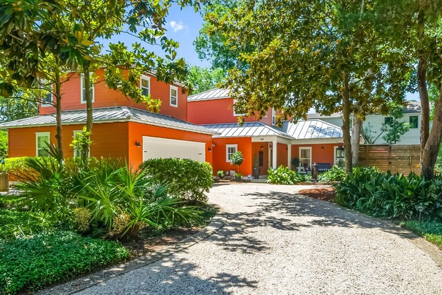 108 S Blue Heron Dr, Santa Rosa Beach, FL 32459 - view of front facade featuring a standing seam roof, gravel driveway, metal roof, an attached garage, and covered porch