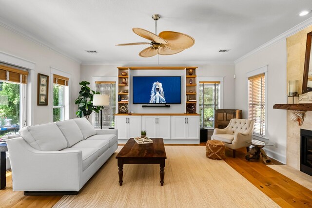 108 S Blue Heron Dr, Santa Rosa Beach, FL 32459 - living room with light wood-style floors, ceiling fan, a fireplace, ornamental molding, and plenty of natural light