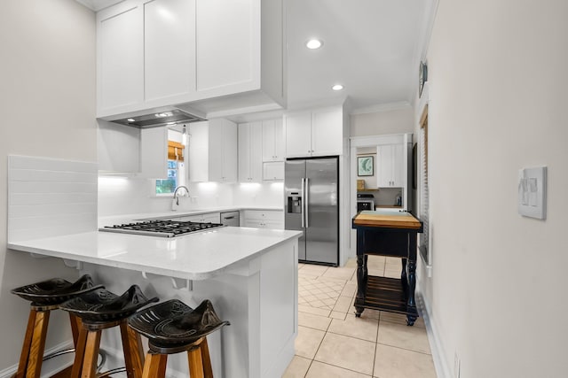 108 S Blue Heron Dr, Santa Rosa Beach, FL 32459 - kitchen with appliances with stainless steel finishes, a peninsula, white cabinetry, light countertops, and a kitchen breakfast bar
