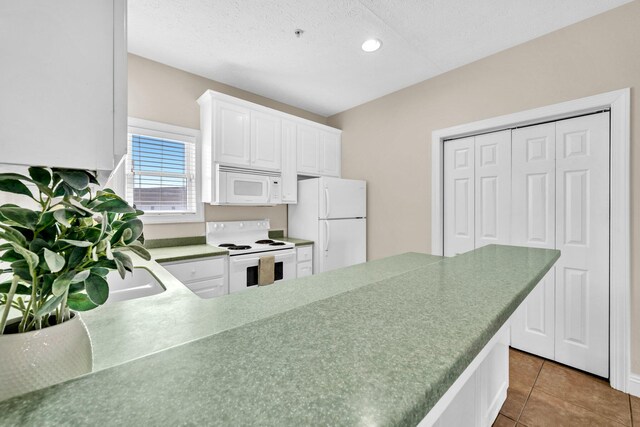 216 Bonita Cir Unit C, Panama City Beach, FL 32408 - kitchen with white appliances, white cabinets, recessed lighting, tile patterned flooring, and a textured ceiling