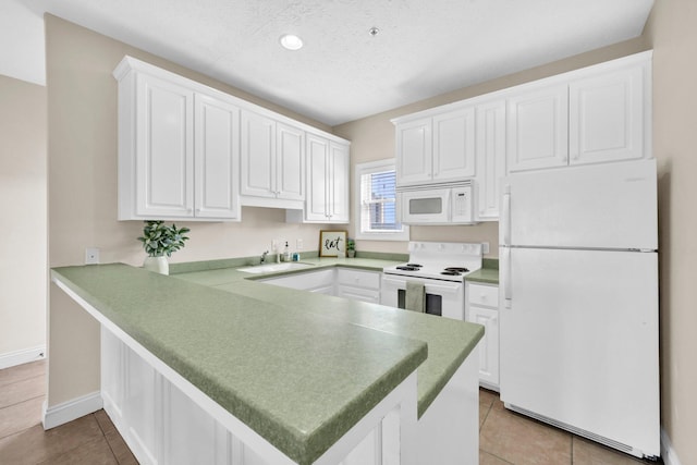 216 Bonita Cir Unit C, Panama City Beach, FL 32408 - kitchen featuring white appliances, a peninsula, a sink, white cabinetry, and a textured ceiling