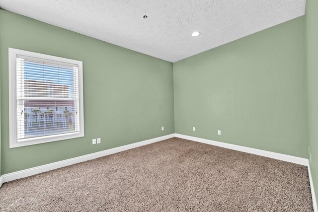 216 Bonita Cir Unit C, Panama City Beach, FL 32408 - spare room with baseboards, carpet floors, a textured ceiling, and recessed lighting