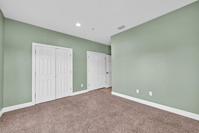 216 Bonita Cir Unit C, Panama City Beach, FL 32408 - unfurnished bedroom with two closets, carpet, baseboards, and recessed lighting