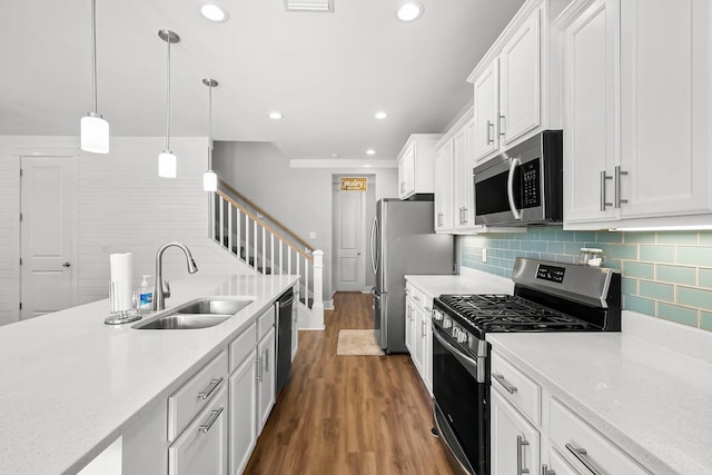 3204 Airport Rd, Panama City, FL 32405 - kitchen featuring stainless steel appliances, a sink, white cabinetry, dark wood finished floors, and tasteful backsplash