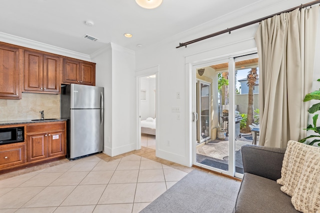 40 W Palm Beach Ct, Miramar Beach, FL 32550 - kitchen featuring freestanding refrigerator, black microwave, a sink, ornamental molding, and brown cabinets