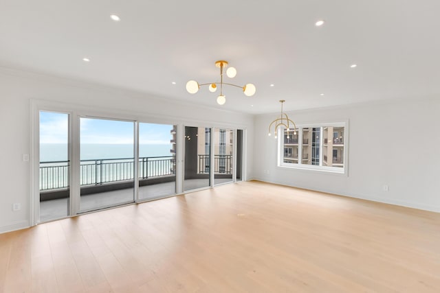 4629 Southwinds Dr Unit 4629, Miramar Beach, FL 32550 - empty room featuring a chandelier, wood finished floors, ornamental molding, recessed lighting, and a water view