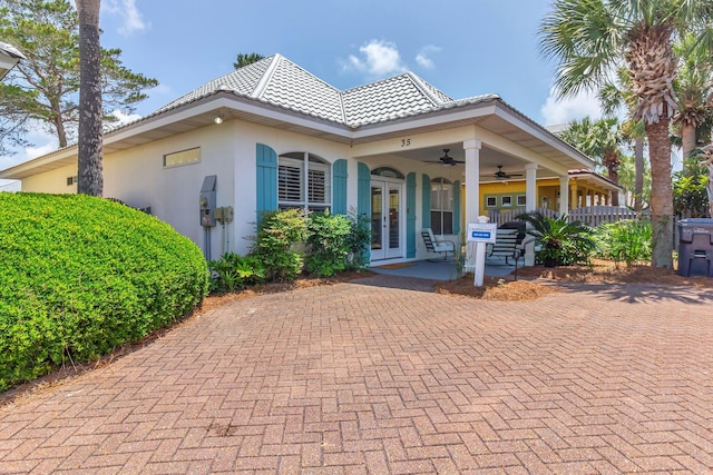 35 Opal Cv, Miramar Beach, FL 32550 - view of front of property featuring french doors, a ceiling fan, stucco siding, a tile roof, and covered porch