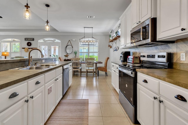 35 Opal Cv, Miramar Beach, FL 32550 - kitchen featuring stainless steel appliances, a sink, ornamental molding, healthy amount of natural light, and tasteful backsplash