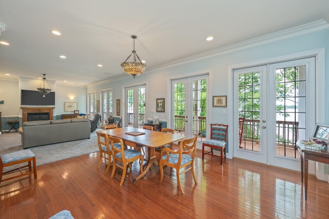 1405 N Bayshore Dr, Niceville, FL 32578 - dining space with french doors, crown molding, wood finished floors, recessed lighting, and a fireplace