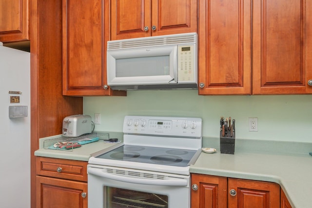1405 N Bayshore Dr, Niceville, FL 32578 - kitchen featuring white appliances, light countertops, and brown cabinetry