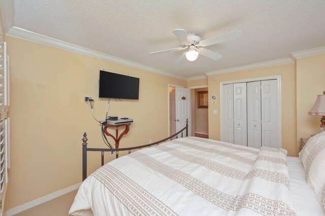 144 Spires Ln Unit 403, Santa Rosa Beach, FL 32459 - bedroom with a closet, crown molding, baseboards, a textured ceiling, and a ceiling fan