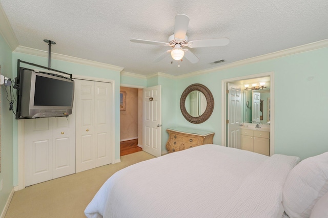 144 Spires Ln Unit 403, Santa Rosa Beach, FL 32459 - bedroom featuring a closet, ornamental molding, a textured ceiling, light colored carpet, and connected bathroom