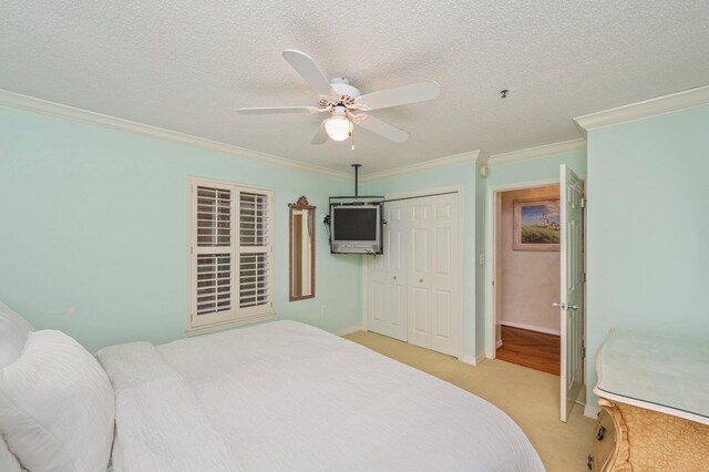 144 Spires Ln Unit 403, Santa Rosa Beach, FL 32459 - bedroom with crown molding, a closet, light carpet, ceiling fan, and a textured ceiling