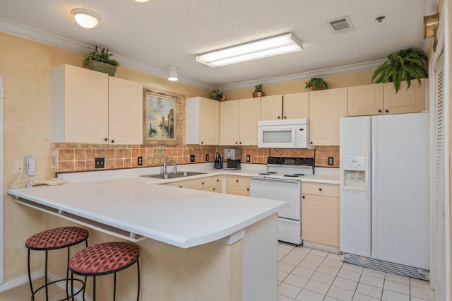 144 Spires Ln Unit 403, Santa Rosa Beach, FL 32459 - kitchen featuring white appliances, a sink, a peninsula, backsplash, and a kitchen breakfast bar