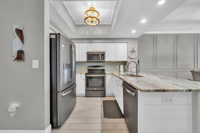 122 Seascape Dr Unit 1104, Miramar Beach, FL 32550 - kitchen with appliances with stainless steel finishes, a sink, a peninsula, white cabinets, and backsplash
