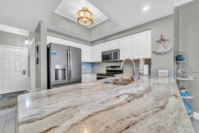 122 Seascape Dr Unit 1104, Miramar Beach, FL 32550 - kitchen featuring appliances with stainless steel finishes, a sink, light stone counters, white cabinets, and a chandelier