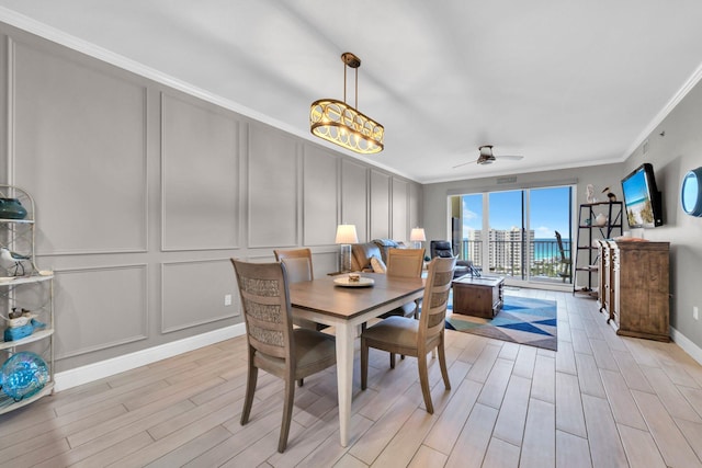 122 Seascape Dr Unit 1104, Miramar Beach, FL 32550 - dining space with a decorative wall, crown molding, light wood-style flooring, ceiling fan, and baseboards