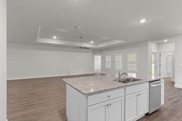 608 Champ Trl, Crestview, FL 32539 - kitchen featuring a raised ceiling, stainless steel dishwasher, a sink, a center island with sink, and white cabinetry