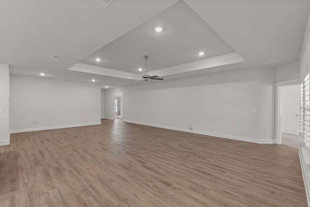 608 Champ Trl, Crestview, FL 32539 - unfurnished living room featuring a raised ceiling, a ceiling fan, crown molding, recessed lighting, and light wood finished floors