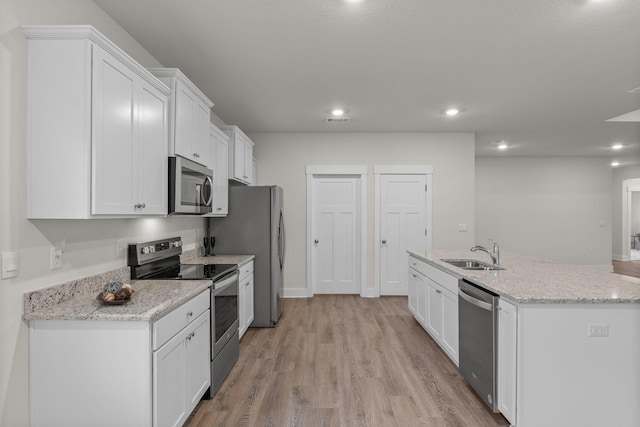608 Champ Trl, Crestview, FL 32539 - kitchen featuring appliances with stainless steel finishes, a sink, white cabinetry, light wood finished floors, and a center island with sink