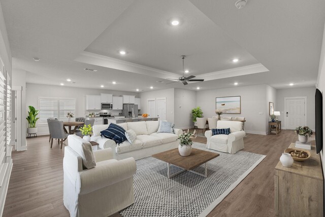608 Champ Trl, Crestview, FL 32539 - living area with a raised ceiling, ornamental molding, a ceiling fan, baseboards, and light wood-type flooring