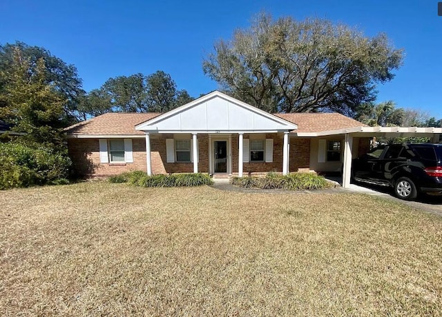123 NW Sotir St, Fort Walton Beach, FL 32548 - view of front of house with an attached carport, a front lawn, covered porch, and brick siding