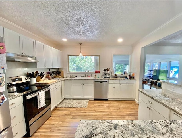 123 NW Sotir St, Fort Walton Beach, FL 32548 - kitchen featuring appliances with stainless steel finishes, under cabinet range hood, a sink, a textured ceiling, and light wood-style floors