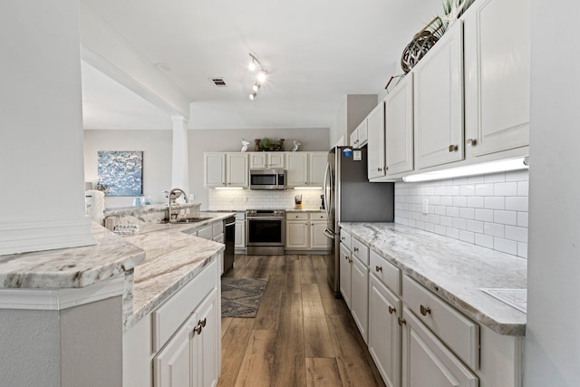 8512 Turnberry Ct Unit 8512, Miramar Beach, FL 32550 - kitchen with stainless steel appliances, a sink, decorative backsplash, dark wood-type flooring, and light stone counters