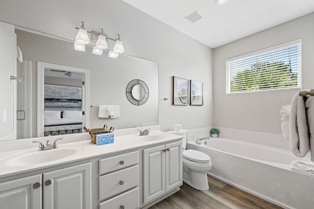 8512 Turnberry Ct Unit 8512, Miramar Beach, FL 32550 - ensuite bathroom with a garden tub, wood finished floors, double vanity, and toilet