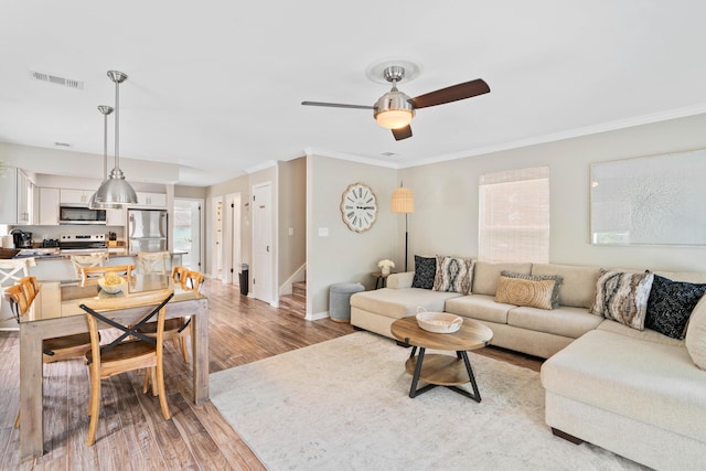 4508 Luke Ave, Destin, FL 32541 - living area featuring ornamental molding, light wood-style flooring, a ceiling fan, baseboards, and stairs
