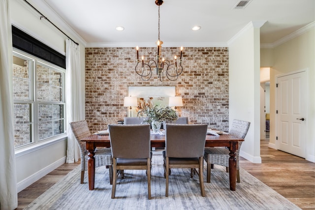 1725 Vinson Ray Rd, Baker, FL 32531 - dining space with brick wall, crown molding, a chandelier, wood finished floors, and baseboards