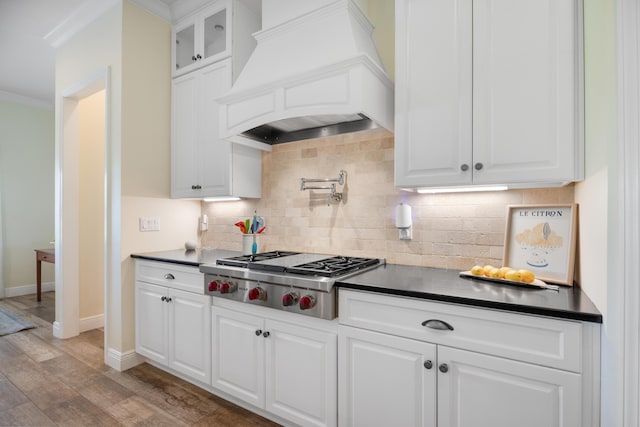 1725 Vinson Ray Rd, Baker, FL 32531 - kitchen with stainless steel gas stovetop, custom exhaust hood, ornamental molding, dark countertops, and light wood-style floors