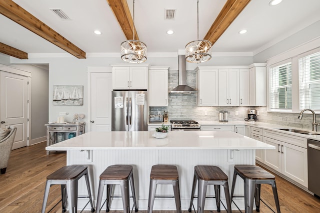 60 Barefoot Ln, Inlet Beach, FL 32461 - kitchen featuring appliances with stainless steel finishes, a sink, wall chimney range hood, a chandelier, and a breakfast bar area