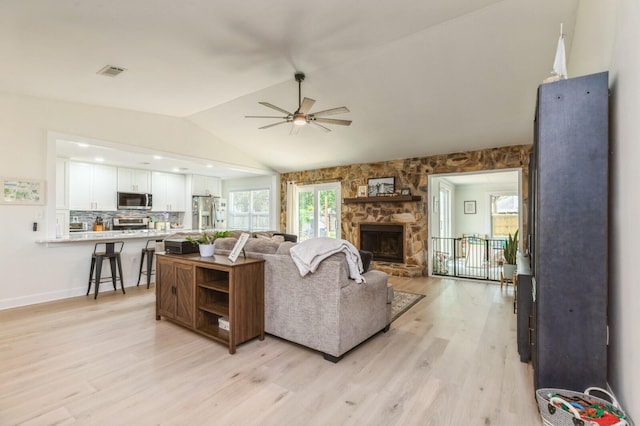 1148 Pin Oak Cir, Niceville, FL 32578 - living room with a ceiling fan, light wood-style floors, lofted ceiling, and a stone fireplace