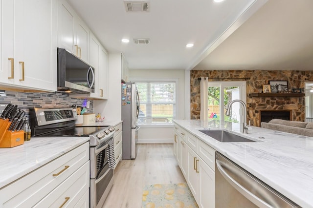1148 Pin Oak Cir, Niceville, FL 32578 - kitchen with stainless steel appliances, a sink, white cabinetry, light stone counters, and recessed lighting