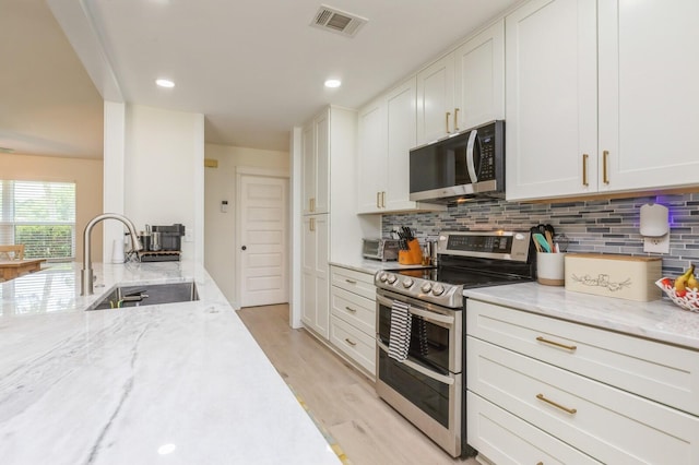 1148 Pin Oak Cir, Niceville, FL 32578 - kitchen with appliances with stainless steel finishes, a sink, decorative backsplash, light stone counters, and recessed lighting