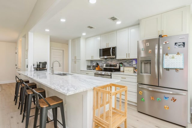 1148 Pin Oak Cir, Niceville, FL 32578 - kitchen with appliances with stainless steel finishes, a sink, light wood-style flooring, white cabinetry, and recessed lighting
