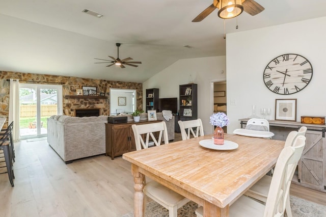 1148 Pin Oak Cir, Niceville, FL 32578 - dining room featuring a ceiling fan, light wood-style flooring, lofted ceiling, and a stone fireplace