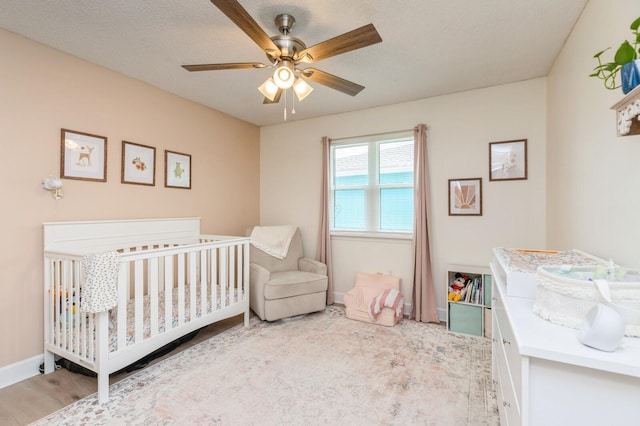 1148 Pin Oak Cir, Niceville, FL 32578 - bedroom with a nursery area, a ceiling fan, baseboards, and wood finished floors